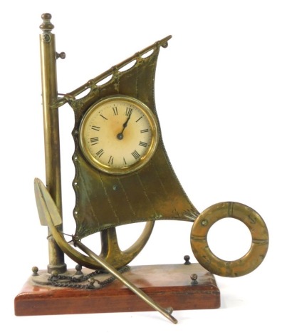 A novelty brass ship's clock, the Roman numeric clock set within the mast and anchor of a ship, on pine base, 26cm high, 19cm wide, 9cm deep.