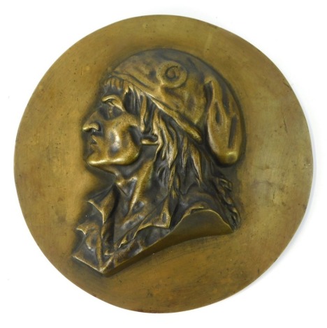 A brass wall plaque, with raised relief central figure of a gentleman in cap, 22.5cm diameter.