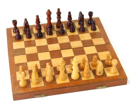 A wooden travelling chess set, the king 6cm high, the travel case 27cm wide, 13cm deep, 5cm high.