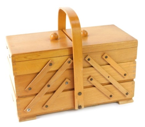 A beech cantilever sewing box, with shaped handle on bracket feet, 26cm high, 32cm wide, 19cm deep.