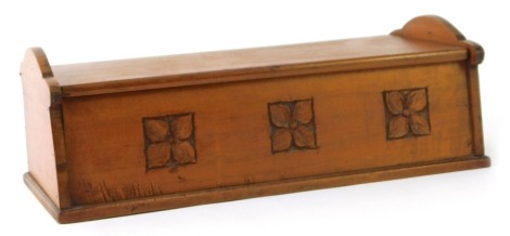 An Arts & Crafts fruitwood box, with shaped end supports, and central panel inlaid with carving of three flowers, 13cm high, 33cm wide, 15cm deep.