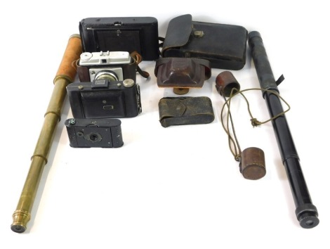 Camera and optics equipment, comprising an Ilford Sporti camera, a Kodak Brownie, Kodak box camera, a Kodak Carlinc box camera, a three draw brass and canvas bound telescope, and a three draw telescope with black metal casing. (1 tray)