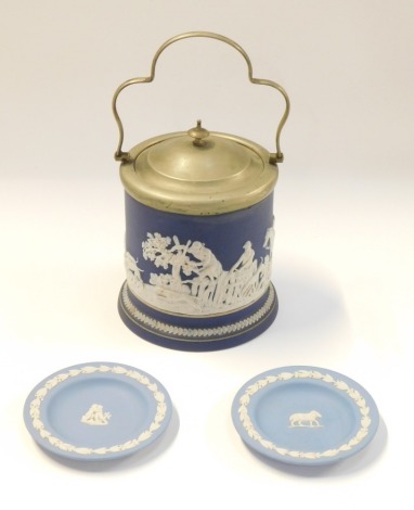 Three items of blue Jasperware, comprising two Wedgwood pin dishes, one with central ram another with two cherubs, 12cm diameter, and a royal blue Tunstall by Adams biscuit barrel, with steel handle and lid, 20cm high. (3)