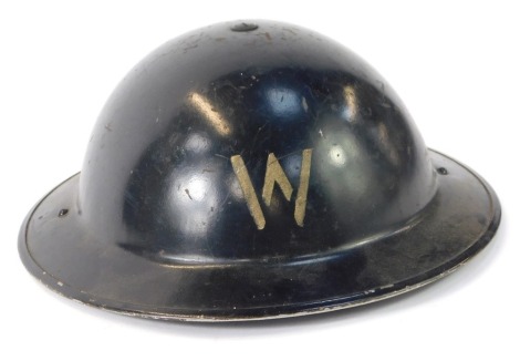 A WWII Army helmet, black background with letter W, 23cm diameter.