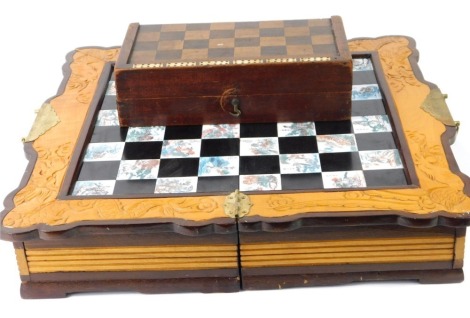 Two chess sets, comprising a Chinese camphorwood folding chess set, with engraved panels of figures and animals, and a further travel example with draughts and dominoes, the largest board 48cm x 50cm. (AF)