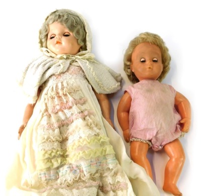 Two 1960s celluloid dolls, one in white pleated gown, 60cm high, and another in pink chequered dress, 40cm high. (2)