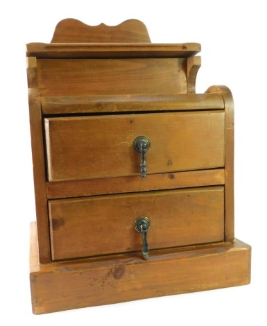 A rustic pine two door desk cabinet, with a hinged lid, opening to reveal letter rack, with moulded cornice on a block base, 50cm high, 36cm wide.