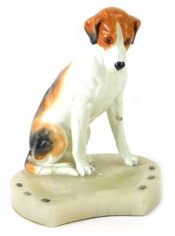 A onyx horseshoe shaped ashtray, with applied ceramic hound, 18cm high. (AF)