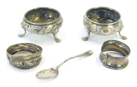 A collection of silver, comprising a pair of Victorian silver salts, London 1847, each with embossed floral design, a silver teaspoon, and two silver napkin rings, 3¼oz. (5)