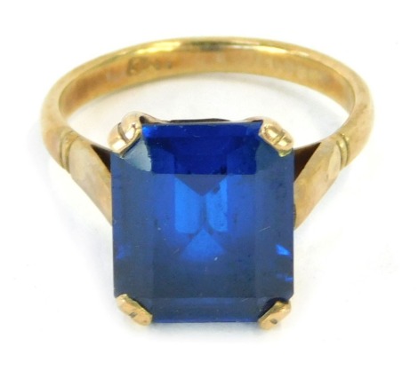 A dress ring, with dark blue rectangular cut paste stone, in a raised claw setting, yellow metal stamped 9ct, size M½, 4.1g all in.