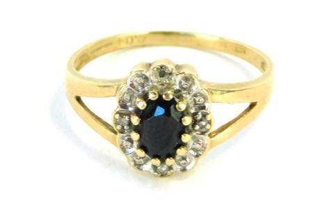 A 9ct gold floral cluster ring, with central dark blue sapphires, surrounded by illusion set tiny diamonds, on V splayed shoulders, size M½, 2g all in, boxed.