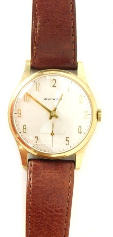 A Garrard 9ct gold cased gentlemans wristwatch, with reverse inscription presented to B Fitzjohn by London Brick Company Ltd in Appreciation of 25 Years Service, with a silvered dial and seconds dial, on a brown leather strap, 33.7g all in.