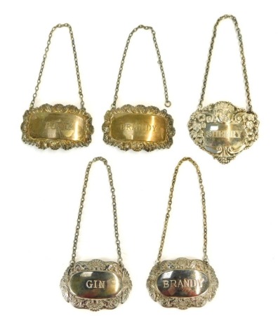 Five decanter labels, comprising three silver labels, one with cherub face marked Sherry, a Port and Brandy shell capped bordered label, 1½oz, and two plated labels for Brandy and Gin. (5, AF)