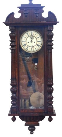 A late 19thC Vienna wall clock, the arched and moulded top on two column supports, with pendulum and two weights, with a thirty day movement, cream Roman numeric dial, 118cm high, 42cm wide, 17cm deep.