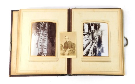 A Victorian photograph album, the leather cover with tulips, and black and white photographs in various panels. (AF)