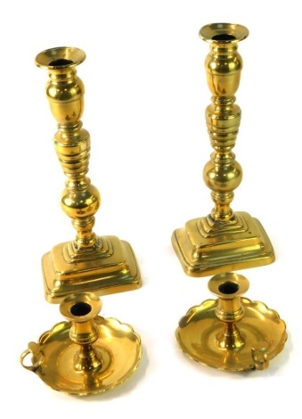 Two early 20thC brass candlesticks, 29cm high, and a pair of brass dwarf chamber candlesticks, each with petalated bases, 10cm high. (4)