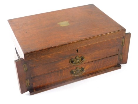 An early 20thC oak cased canteen of cutlery, the canteen with reeded columns and two pull out drawers, and brass swag handles and plated cutlery, some with bone handles, 20cm high, 41cm wide, 29cm deep.