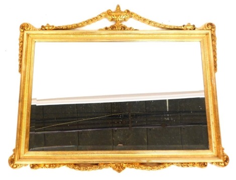 A gilt framed rectangular wall mirror, with urn finial top and scroll and shell capped surround, 86cm high, 104cm wide, 5cm deep.