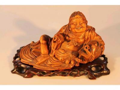 A Chinese carved hardwood figure of Hotei in a recumbent pose