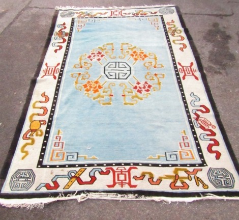 A Chinese wool pile rug, cream ground with bold colour design and black borders, tassel ends, 258cm x 178cm.