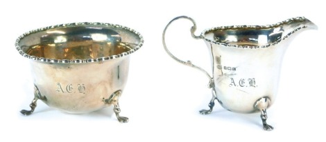 A George V silver cream and sugar bowl, beaded border, tripod claw feet, Birmingham 1927, 5oz. (2, AF)