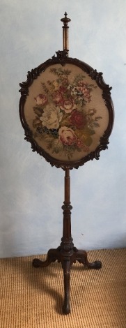 A Victorian mahogany pole screen, with shaped wool work panel of roses, 152cm high, 47cm wide, 45cm deep.