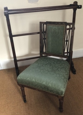 An Edwardian rosewood nursing chair, upholstered in green fabric, 72cm high, and a Victorian mahogany towel rail, 86cm high, 80cm wide, 22cm deep. (2)