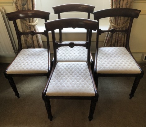 A set of four William IV mahogany dining chairs, with overrun cresting rails, drop in seats and reeded forelegs.