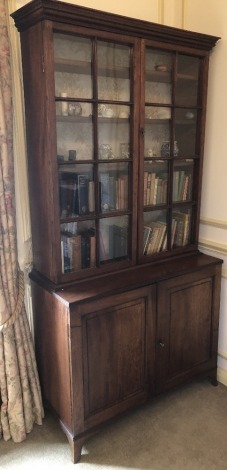 A George III mahogany cabinet, with a moulded cornice above two astragal glazed doors, the base with two panelled doors on splayed feet, 205cm high, 102cm wide, 45cm deep.