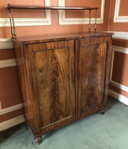 A Regency flame mahogany chiffonier, with a brass galleried top and shelf with turned brass supports, two door cabinet base on turned legs, 125cm high, 87cm wide, 35cm deep.