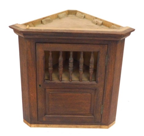 A stained pine hanging corner cabinet, with a galleried top, an enclosed base, 53cm high, 52cm wide and 28cm deep.