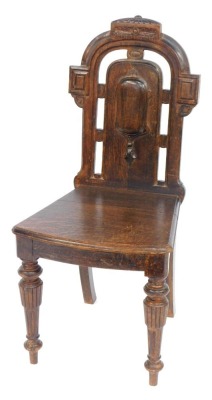 A 19thC oak hall chair, with a carved top and moulded back, on reeded tapering legs, 96cm high, 44cm wide, 40cm deep.