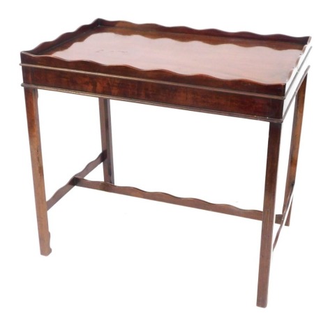 A Georgian style flamed mahogany tray top silver table, with a shaped gallery, on tapering legs, 73cm high, 80cm wide, 51cm deep.