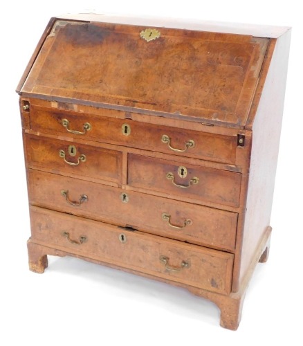 A George I walnut bureau, the fall opening to reveal a fitted interior, plate above arrangement of one long, two short and two long drawers on bracket feet, 106cm high, 91cm wide, 52cm deep. (AF)