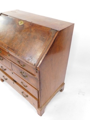 A George I walnut bureau, the fall opening to reveal a fitted interior, plate above arrangement of one long, two short and two long drawers on bracket feet, 106cm high, 91cm wide, 52cm deep. (AF) - 2