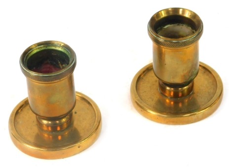 A pair of early 20thC industrial design bronze dwarf candlesticks, each with a hatched banded rim, each 7cm high.