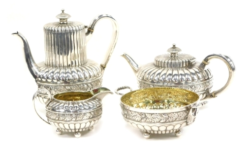 A Victorian silver and silver gilt four piece tea service, by Goldsmiths Alliance Limited, comprising teapot, water jug, 19cm high, two handled sugar bowl and milk jug, heavily decorated with a repousse banding of acorn leaves and flower heads on orb feet