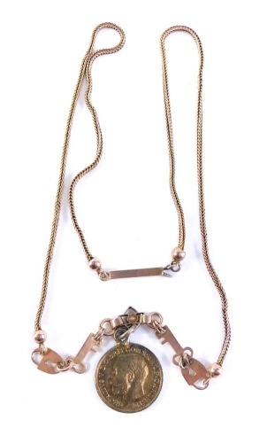 A slender link necklace, with key fasteners attached to a gold coloured threepenny bit, 40cm long.