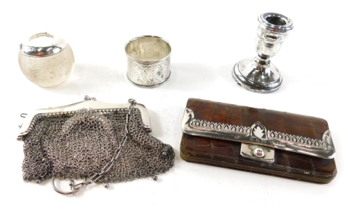 A mid 20thC chain mail evening purse, a crocodile skin finish purse with silver mounts, dwarf candlestick, napkin ring, glass match strike with silver top, various dates and makers. (a quantity)