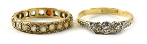 Two dress rings, comprising a 18ct gold and platinum diamond three stone illusion set dress ring, size O, 3.6g, and a 9ct gold and silver eternity ring, ring size M½. (2)