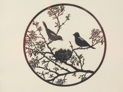 An early 20thC silhouette of birds nesting in a blossoming tree, unsigned, 14cm diameter.