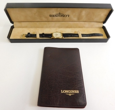 A Longines quartz wristwatch, with oval 2cm wide dial with baton and Roman numeric numerals, black leather strap, in outer case with paperwork. - 2