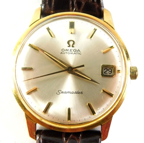 An Omega Seamaster automatic wristwatch, the silvered 3cm diameter dial with baton pointers and numerals, with date aperture and textured leather strap, with outer case and paperwork.