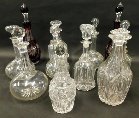 Various decanters, to include a matched pair of flash ruby glass examples with stoppers, each approximately 37cm high, various others, mallet shaped example with compressed mushroom stopper, another with orb stopper, various other cut glass decanters, etc