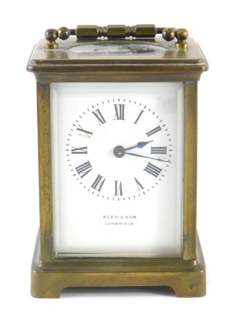 A 20thC Reed & Sons carriage clock, in five part glazed brass case with swing handle, 6cm back plate with Roman numeric dial and visible barrel movement, with key.