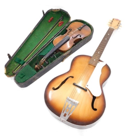 A violin with two piece back, paper label for Stradivarius 1720, maker KS, back 35cm long, and a Prince acoustic guitar, with a maple case and stained wooden fret board.