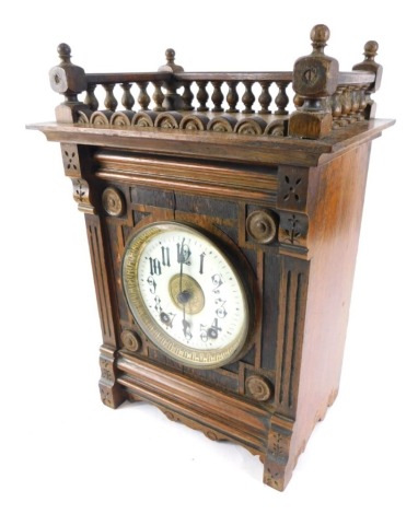 An early 20thC oak mantel clock, with a three part galleried top raised above 14cm diameter Arabic dial, with a heavily carved case on shaped stiles, with eight day movement striking on the hour, 42cm high.