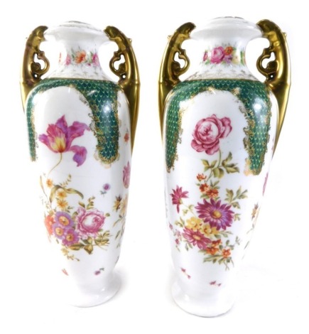 A pair of Sitzendorf porcelain vases, each transfer printed with flowers, with gilt highlighted pierced handles, on circular feet, double cross sword marks beneath, 30cm high.