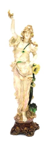 An E. W. Turin Wien Austrian porcelain Art Nouveau figure of a lady, in flowing robes holding shell, on shaped base, marked beneath.