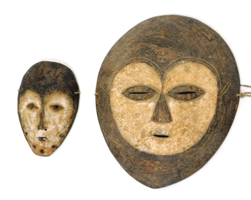 An African tribal Kwele wall mask formed as a face with shield backing, 30cm high and another.